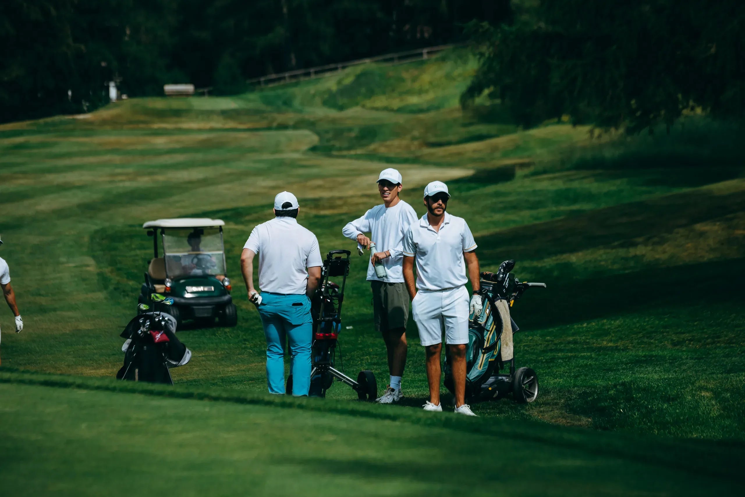 Group of golfers on an alpine fairway with a cart wearing KADI apparel