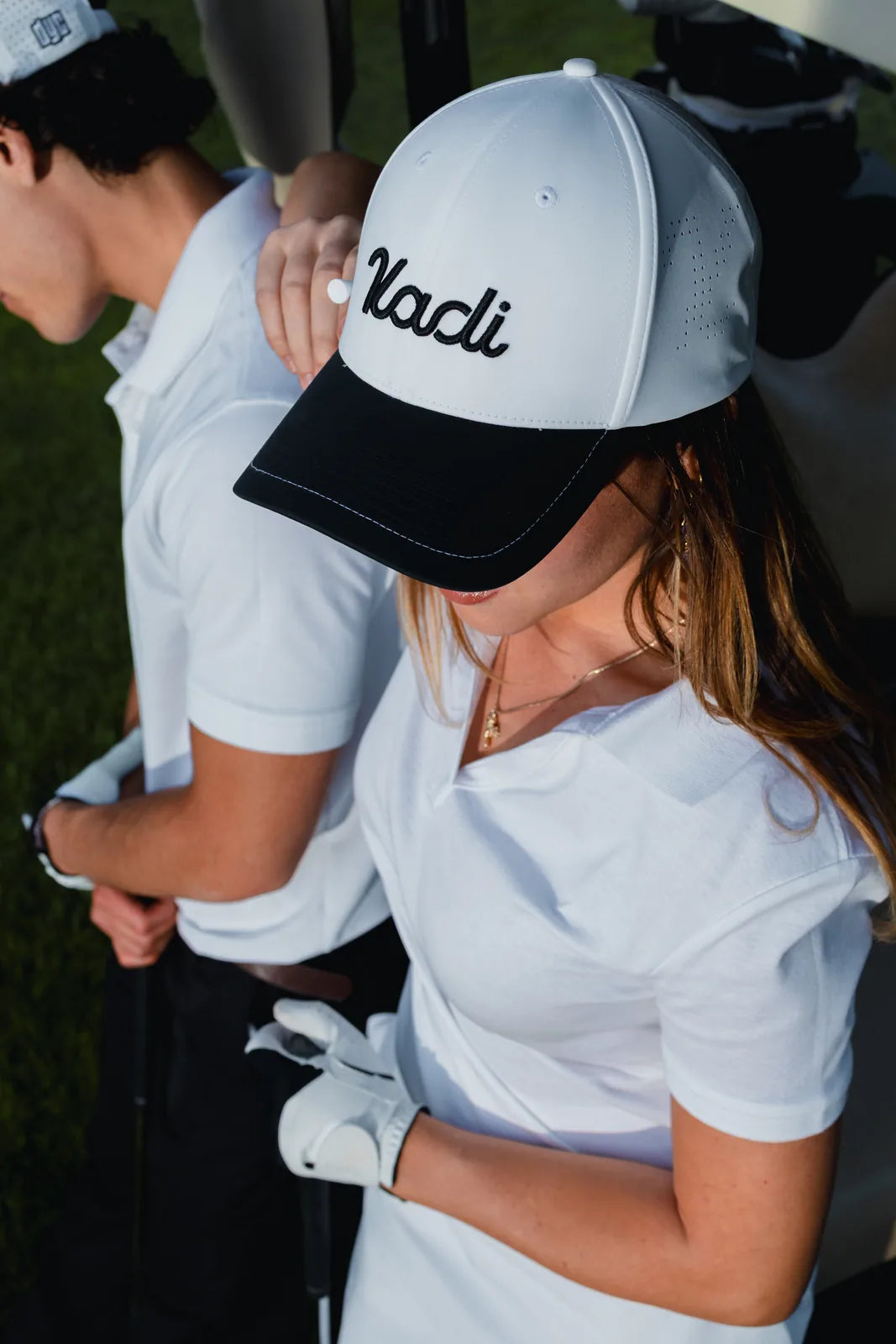 Close-up of a woman in a white KADI cap and polo